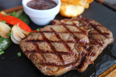 Kırmızı şarap soslu ızgara pirzola, sıcak taş tabakta servis edilir.