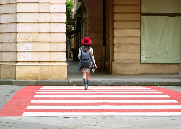 Młoda Kobieta Czerwonym Kapeluszu Walking Red White Crosswalk — Zdjęcie stockowe