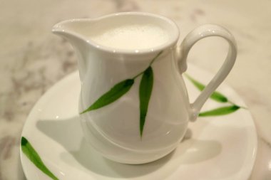 Daire üzerinde yeşil yapraklı süt sürahisi