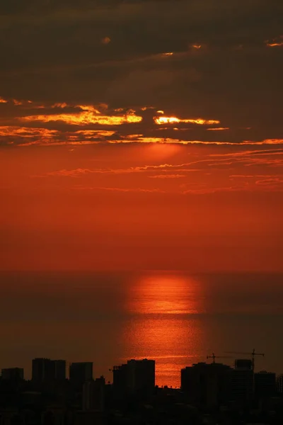 Spiegelungen Des Untergehenden Sonnenlichts Über Dem Meer Mit Wolkenkratzer Silhouette — Stockfoto