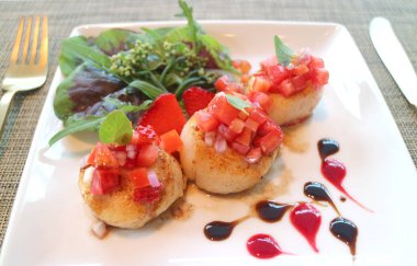 Domates salsa ve yeşil salata ile nefis kurutulmuş deniz tarağı.