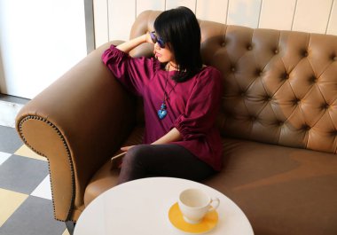 Masada boş bir kahve fincanı olan bir kadın.