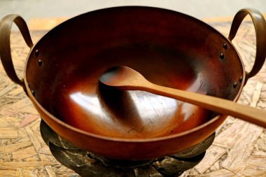 Pirinç tava ve ahşap kürek ev yapımı kahve için kavrulmuş kahve çekirdekleri.