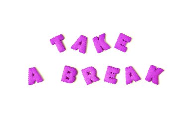 Beyaz arkaplanda canlı pembe alfabe şekilli kurabiyelerle yazılmış Take A Break kelimesi