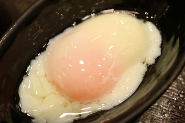 Kapalı, kaynamış bir yumurtayı siyah bir taş kasede servis ettim.