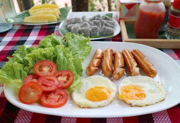 炒蛋和炸腊肠 配新鲜绿色沙拉 早餐时背景模糊的水果 — 图库照片