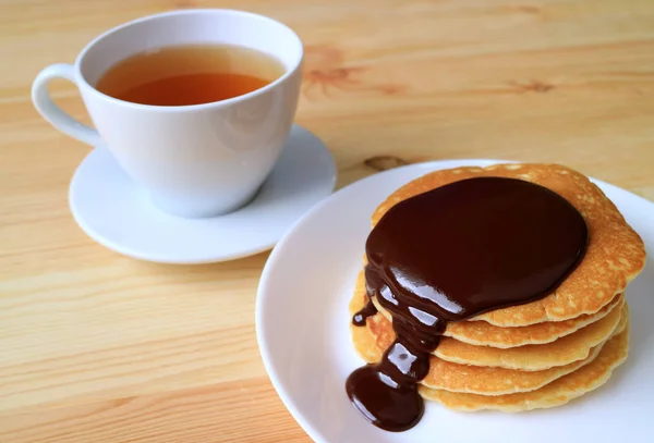 Пачка Блинчиков Аппетитным Бельгийским Шоколадным Соусом Чашка Горячего Чая Заднем — стоковое фото