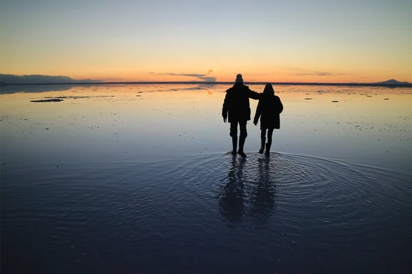 图片说明一对有爱心的夫妇在南美洲玻利维亚乌尤尼盐滩的神奇镜像效果 — 图库照片