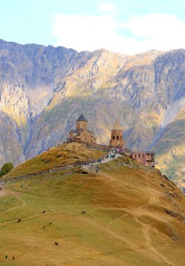 Pek çok ziyaretçi Gergeti Trinity Kilisesi, Stepantsminda kasabası, Kazbegi, Georgia 'ya tırmanıyor.