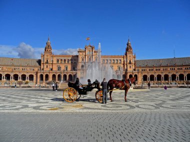 İspanya, Seville 'deki Plaza de Espana meydanında Vicente Traver çeşmesinin önünde at arabası var.
