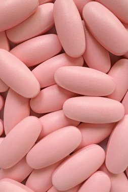 Arka plan veya afiş için pembe oval şekilli hapların dikey görüntüsü