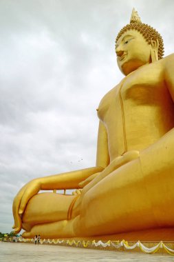 Tayland 'ın Ang Tanga bölgesindeki Wat Muang Tapınağı' nda 92 metre yüksekliğinde oturan altın Buda resmi.