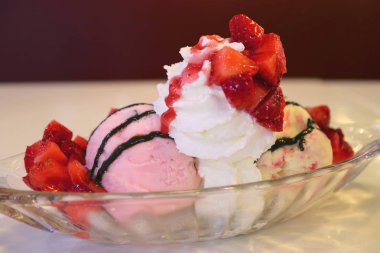 Üstünde taze çilek ve krem şantili dondurma.