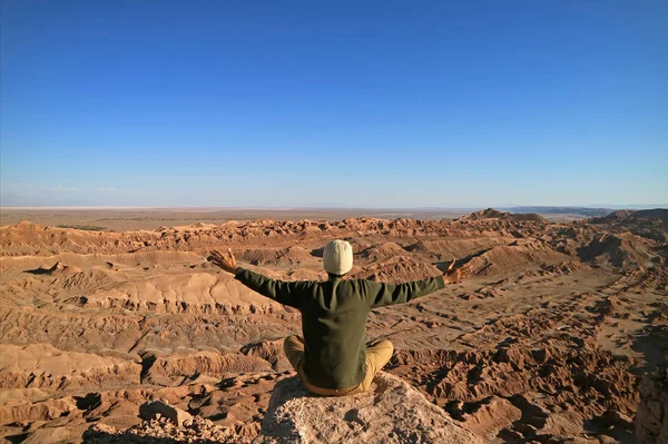 Mann Der Auf Dem Felsen Sitzt Und Die Arme Hebt — Stockfoto