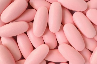 Arkaplan veya afiş için açık pembe renkli oval şekilli hapların üst görünümü
