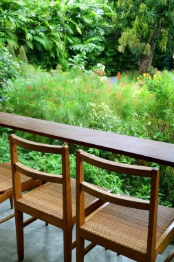 Boş ahşap sandalyelerin ve bahçedeki masanın dikey görüntüsü