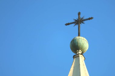 Gorgeous cross of the bell tower's top of Basilica Cathedral of Arequipa against bright blue sky, Arequipa, Peru