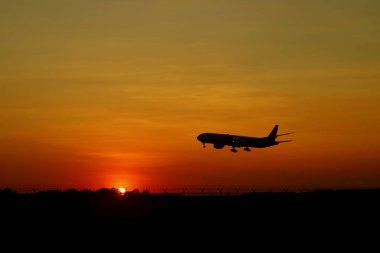 Güzel gündoğumu gökyüzünde uçan uçağın silueti