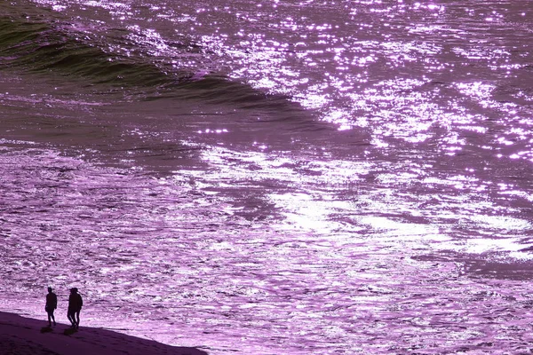 流行艺术超现实风格的紫色波浪形大海 人们沿着海滩散步的轮廓 — 图库照片