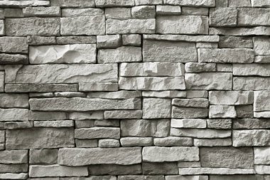 Arkaplan için monoton gri kaba taş duvar ön görünümü
