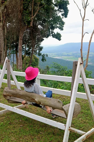 Female Wearing Vibrant Pink Straw Hat Sitting Wooden Swing Looking — 스톡 사진