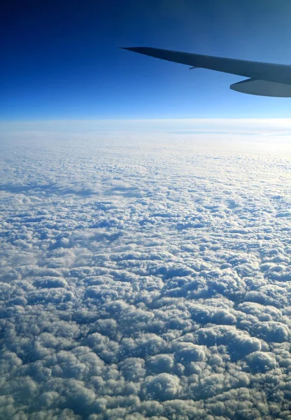 飛行中に飛行機から見た飛行機の翼を持つ深い青い空と純粋な白い雲 — ストック写真