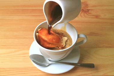 Bir sürahi sıcak espresso kahveyi aromatik ve lezzetli bir Affogato için vanilyalı dondurmanın üzerine döküyorum.