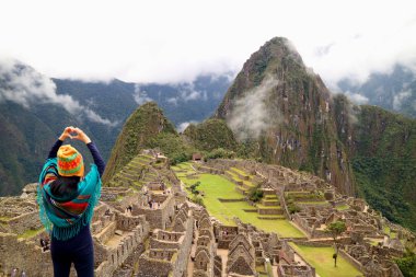 Machu Picchu, Cusco, Peru 'nun ünlü İnka kalıntılarına bir aşk işareti taşıyan dişi turist.