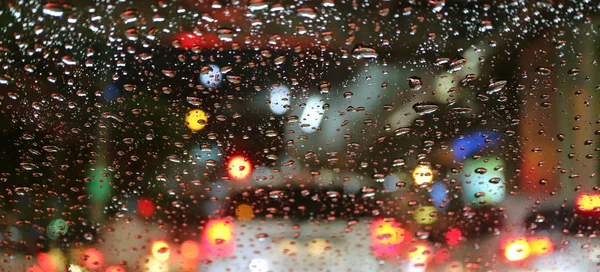 Zamazane Światła Tylne Pojazdu Oglądane Przez Krople Wody Szybie Samochodowej — Zdjęcie stockowe