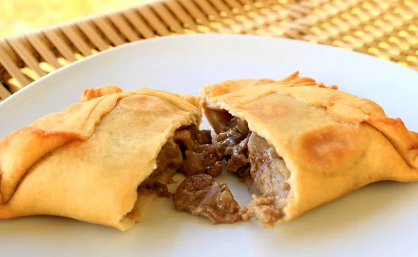 Empanada ya da Empanada de Pino sığır eti, beyaz tabakta servis edilen lezzetli Şili fırınlanmış hamur.
