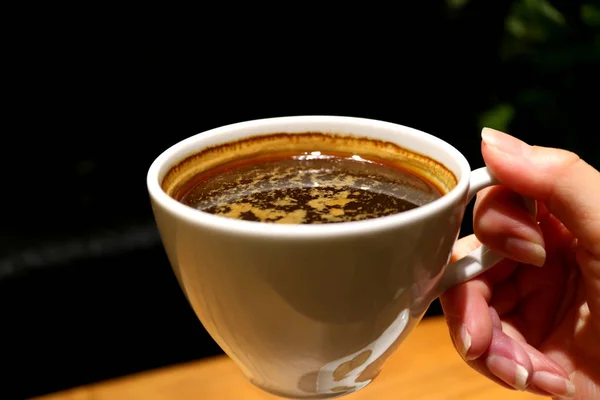 Vrouwelijke Hand Holding Een Kopje Hete Koffie Warme Verlichte Donkere — Stockfoto