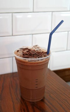 Çikolata parçacıkları ile kaplı buzlu çikolata. Tahta masaya izole edilmiş.