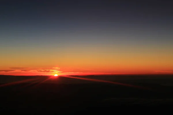 飛行中の飛行機の窓から見た雲の上の日の出の信じられないほどの眺め — ストック写真