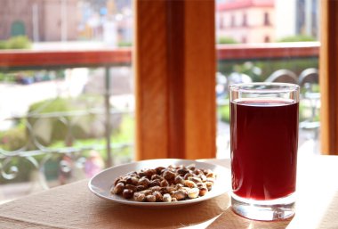 Chicha Morada, Peru 'nun popüler geleneksel içecekleri bir tabak And usulü kızarmış mısırla servis ediliyor.
