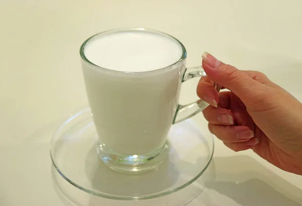 Woman Hand Holding Cup Warm Buffalo Milk Served Transparent Glass — 스톡 사진