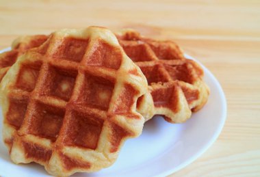 Bir çift Belçika Waffle 'ını kapadım. Tahta Masa' da servis edildi.