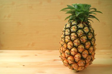 Taze olgun ananas bütün meyve ahşap zemin üzerinde, metin ve tasarım için boş alan ile