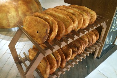 Fırın ahşap raflarında geleneksel Ermeni ekmekleri satılıyor.