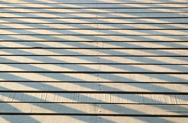 Cień Balustrady Świetle Słonecznym Odbija Się Drewnianej Promenadzie — Zdjęcie stockowe