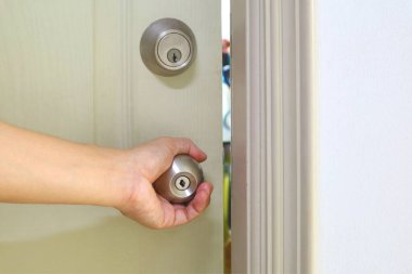 Kapıyı açmak için adamın eli kapı kolunu tutuyor.