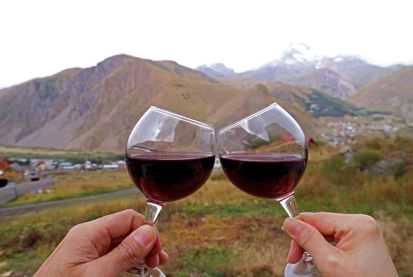 Mãos Segurando Copos Vinho Clinking Com Visão Montanhas Embaçadas Fundo — Fotografia de Stock