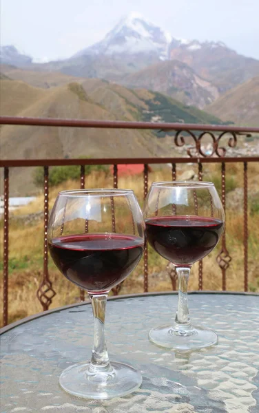 Dois Copos Vinho Tinto Uma Mesa Vidro Com Monte Kazbek — Fotografia de Stock