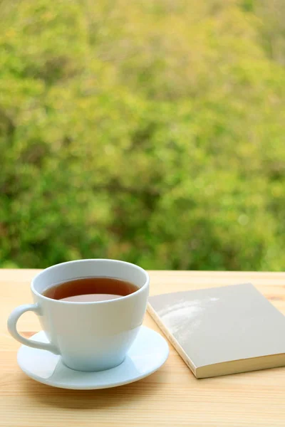 Vertical Image Cup Hot Tea Book Outdoor Table Blurry Foliage — Stock Photo, Image