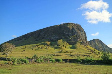 Rano Raraku yanardağının inanılmaz panoramik manzarası. Efsanevi Moai taş ocağı. Şili 'nin yamaçlarında sayısız Moai heykeli kalıntıları var.