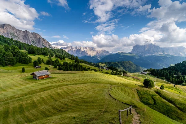 Les champs d'herbe verte et une cabane dans la belle vallée de Val Gardena dans les montagnes Dolomites, Alpes, Italie . — Photo