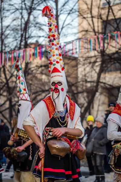 Mummers eseguire rituali per spaventare gli spiriti maligni al festival Surva a Pernik in Bulgaria. Le persone con le maschere si chiamano Kuker (kukeri). Maschera con baffi . — Foto Stock