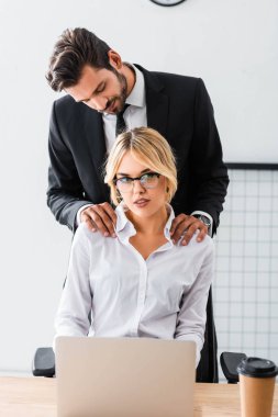 İş adamı ofiste seksi bir iş kadınıyla flört ediyor.
