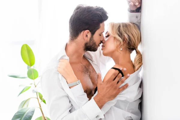 Ofiste iş adamının seksi meslektaşını öptüğünün yan görüntüsü