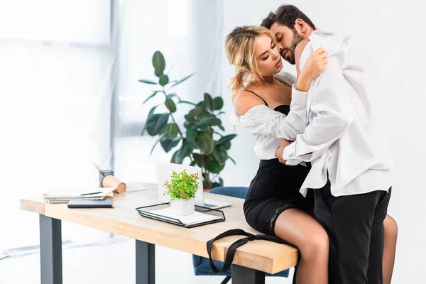 Seksi iş çifti ofis masasında tişörtlerini çıkarıyor.