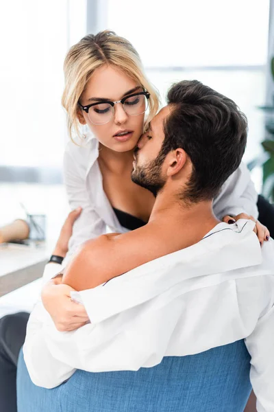 Seksi iş kadını ofiste iş arkadaşı gömleğini çıkarıyor.